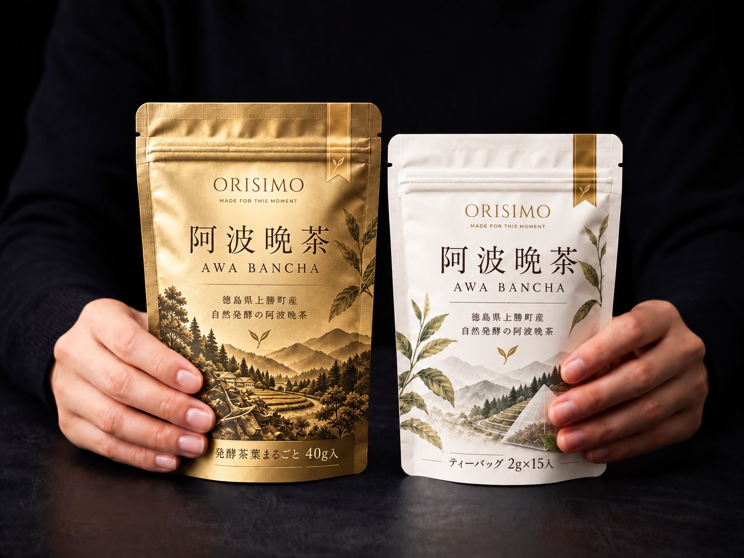 ORISIMO 上勝阿波晩茶の金色（茶葉40g）と白色（ティーバッグ）のパッケージを両手で持つ写真